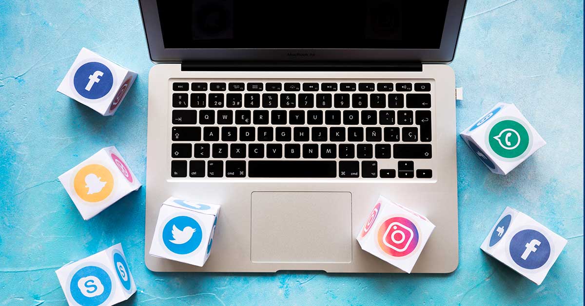 Laptop και κύβοι με λογότυπα των social media, τα οποία είναι βασικό εργαλείο του social media marketing
